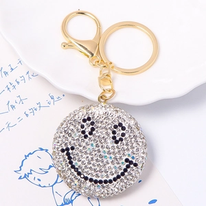 Dettaglio ravvicinato di un portachiavi a sorriso con strass bianchi e chiusura dorata