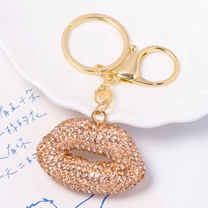 Macro shot of sparkling champagne rhinestone lip keychain with gold metal clasp