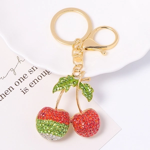 Porte-clés cerise étincelant avec strass rouges et verts sur un anneau en métal doré