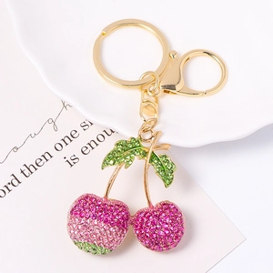 Vue détaillée du porte-clés cerise avec strass roses et fermoir en métal doré