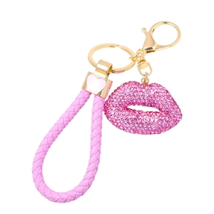 Detail of pink rhinestone lips keychain with braided leather strap and gold hardware