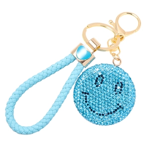 Dettaglio del cinturino in pelle intrecciata blu e clip in metallo a cuore su un portachiavi