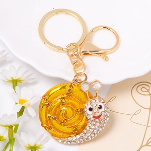 Macro detail of luxury snail keychain with yellow crystals and pavé rhinestones