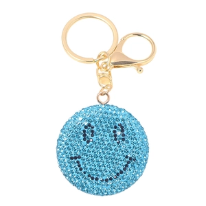 Dettaglio portachiavi smiley con strass blu e chiusura in metallo dorato di lusso