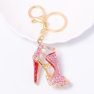 Pink rhinestone high heel keychain in gold alloy with lobster clasp on white plate