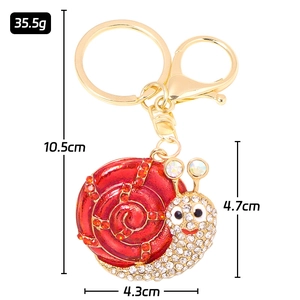 Luxury snail keychain with red enamel and crystals, featuring golden ring and dimensions