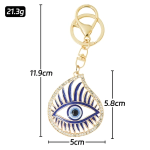 Golden Evil Eye keychain with sparkling rhinestones and blue enamel on white background