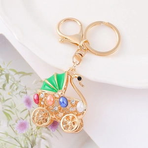 Macro detail of golden swan carriage keychain with colorful gemstones and rhinestones