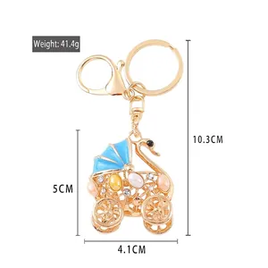 Golden swan-shaped stroller keychain with blue crystals and rhinestones charm
