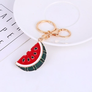 Detail of watermelon keychain featuring red enamel and sparkling rhinestones on a tray