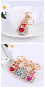 Detail of rhinestone money bag keychains in red, blue, and pink heart variations