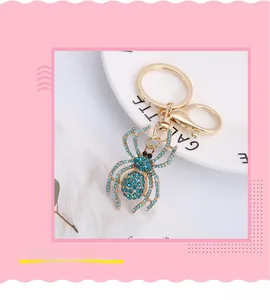 Close-up of gold spider keychain with sparkling blue rhinestones and lobster clasp