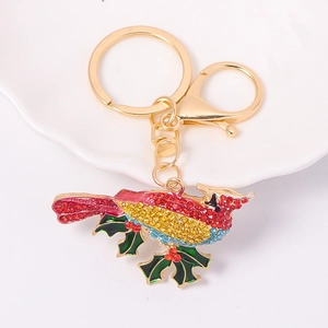 Detail of red rhinestone bird keychain with green enamel leaves and golden clasp