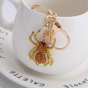Creative spider keychain with amber and green rhinestones on golden alloy metal frame
