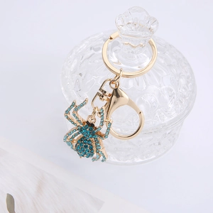 Creative spider keychain featuring light blue crystals and golden alloy on glass jar