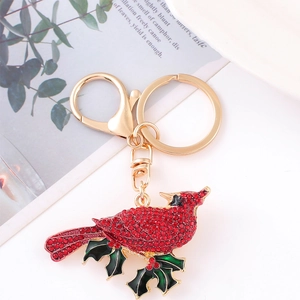 Luxurious red bird rhinestone keychain with gold plating and green enamel holly leaf charm
