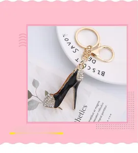 Détail de porte-clés escarpin doré avec émail noir et strass brillants sur le dessus