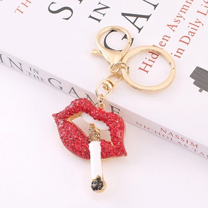 Detail showing red rhinestone lips and cigarette charm with gold lobster clasp and ring
