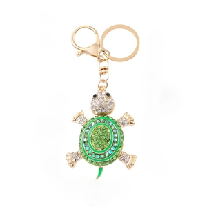 Macro shot of gold turtle keychain with vibrant green and blue gradient rhinestones