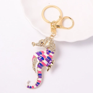 Macro shot of seahorse keychain with purple enamel and sparkling crystal rhinestones