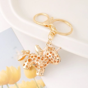 Exquisite gold unicorn keychain with hollow rhinestone mesh on a white ceramic plate