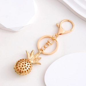 Golden pineapple keychain with hollow design and rhinestone accents for bag decoration
