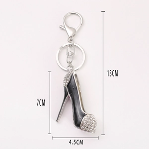 Porte-clés escarpin noir avec strass blancs et dimensions de 13cm de long sur fond blanc
