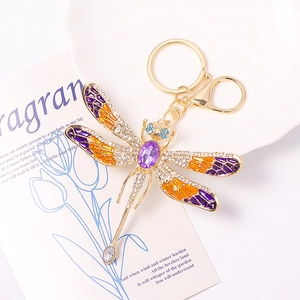 Detailed macro view of dragonfly keychain with purple crystal and enameled wings