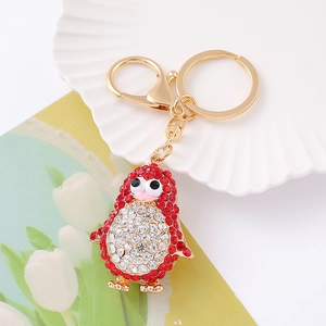 Porte-clés manchot scintillant avec strass rouges et blancs sur métal doré brillant
