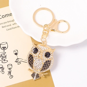 Detail of owl keychain with gold plating, sparkling white rhinestones and black enamel accents