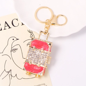 Porte-clés valise en métal doré avec émail rouge et strass brillants de luxe