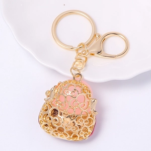 Golden Hello Kitty hollow pendant keychain with pink resin ball on white plate