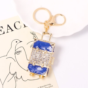 Détail du porte-clés valise en émail bleu avec strass et finition en métal doré