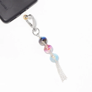 Close-up of handmade gradient bead phone strap with silver tassel and heart clasp