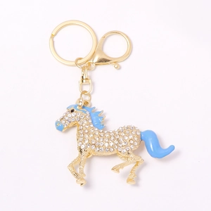 Golden horse keychain with white rhinestones and blue enamel details on white background