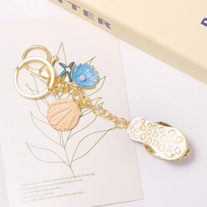 Sleutelhanger met oceaanthema met roze schelpen, zeester en slipper hanger met hartpatroon