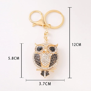 Golden owl keychain with white rhinestones and black enamel detail including size dimensions
