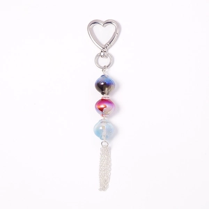 Luminous bead keychain with heart-shaped metal clasp and long tassels on white background
