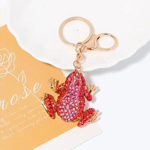 Detail of a sparkling gold frog keychain with red rhinestones and a lobster clasp