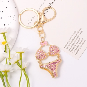 Detail of pink rhinestone bikini keychain with golden alloy finish and lobster clasp