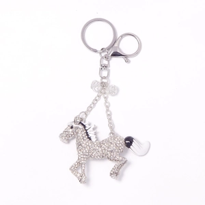 Porte-clés cheval en métal argenté avec strass brillants et détails de queue noir et blanc