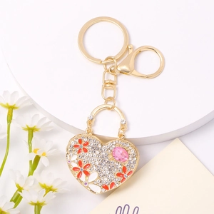 Elegant heart-shaped keychain with rhinestones, flower patterns and a pink crystal gem