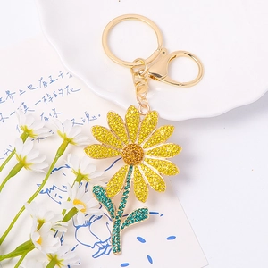 Close-up of a sparkling metal daisy keychain with colorful yellow and blue rhinestones