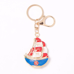 Golden sailboat keychain with rhinestone accents and good luck enamel charms