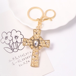 Vintage golden cross keychain with crystal drop pendant and embossed metal details