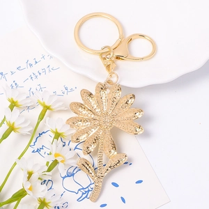 Elegant gold daisy flower keychain with rhinestones and textured metal petals