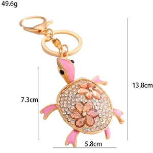 Sparkling sea turtle keychain with rhinestones and orange flowers in gold alloy