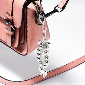 Portachiavi con perline d'argento e ciondolo a fiocco su una borsa in pelle rosa