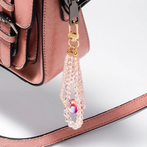 Pink crystal bead phone charm with zinc alloy lobster clasp on a leather handbag