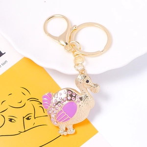 Close-up of golden dodo duck keychain with pink rhinestones and enamel details